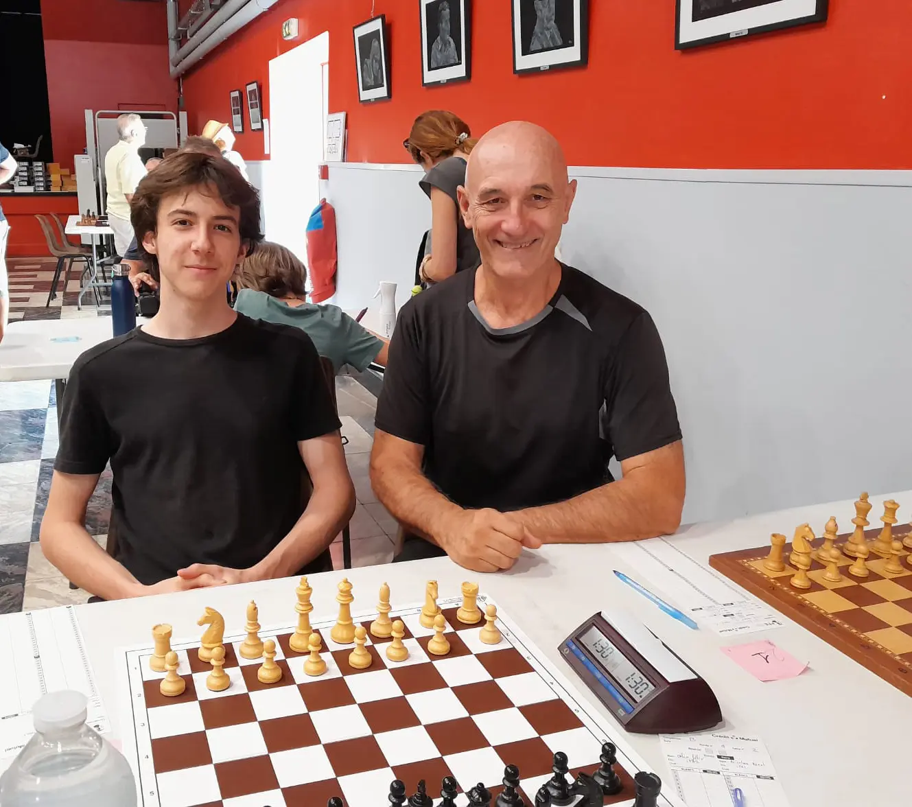 Jaouen Bertrand et Jean-Marc Misik souriants devant leur échiquier au festival de Saint-Antonin-Noble-Val